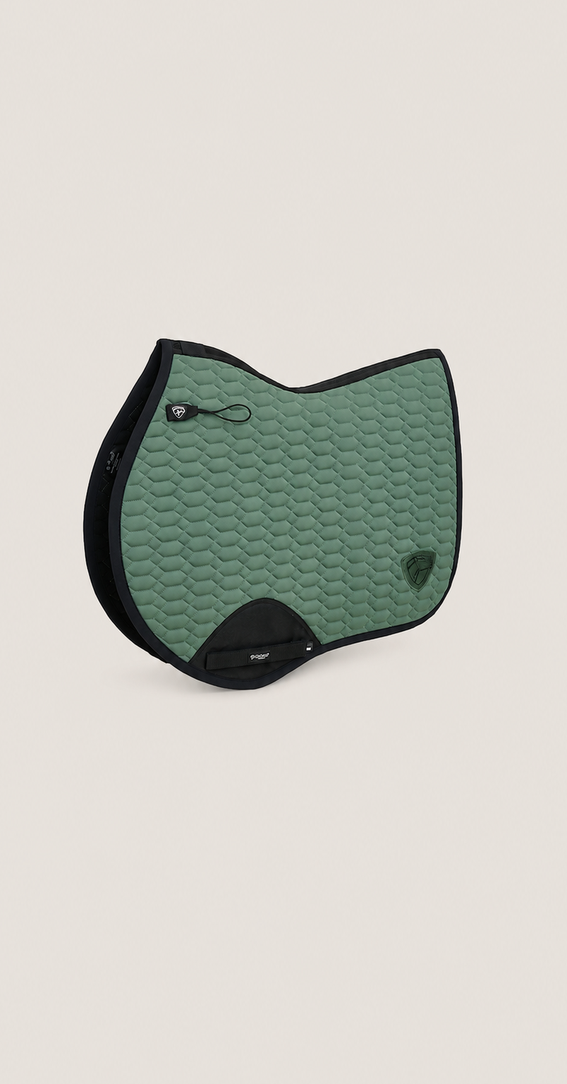 A green quilted equestrian saddle pad with Fir Tech technology black trim and a small embroidered logo, displayed on a solid light beige background.